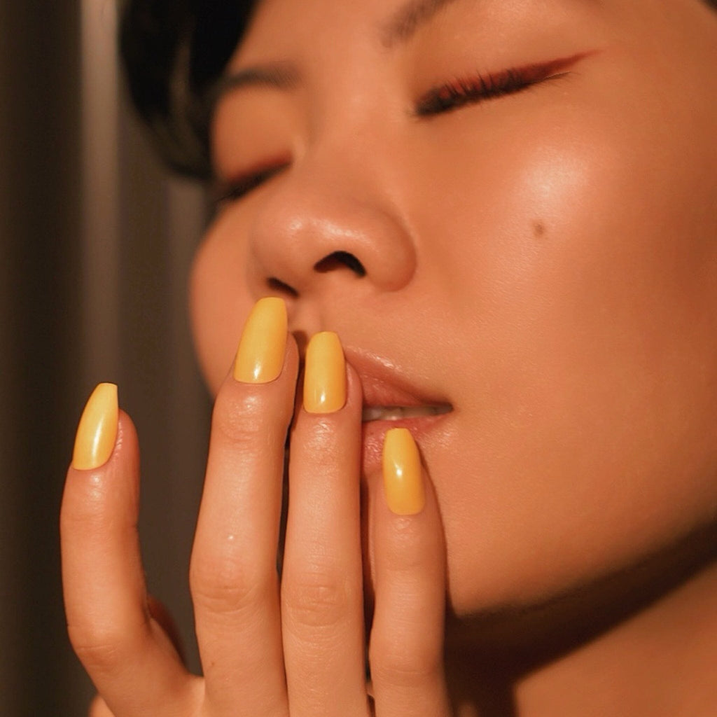 Press on nails in Big Glam Nation's Honeycombs worn by beautiful olive skinned model against face in portrait style photo with an evening glow.