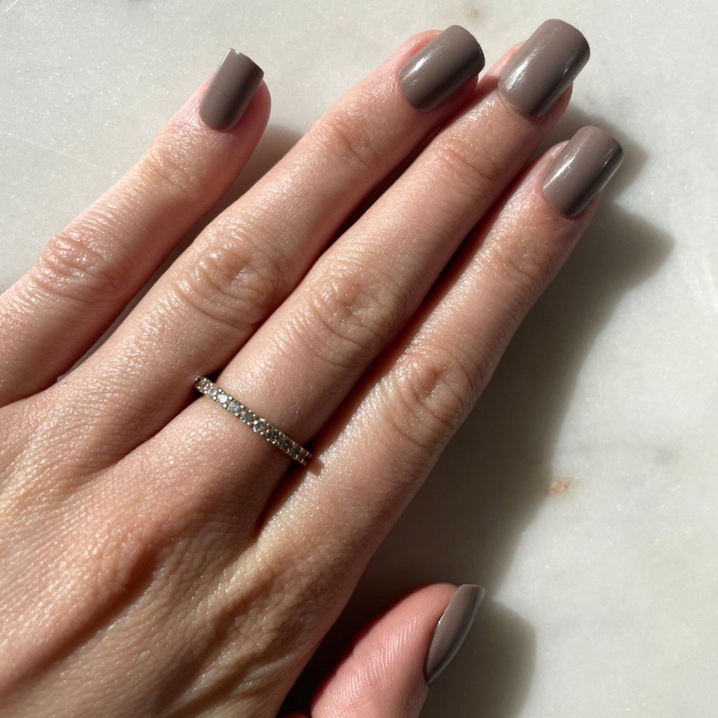 Short Press on Nails in Big Glam Nation's Burgundy and Charcoal on fair-skinned model against pale background.