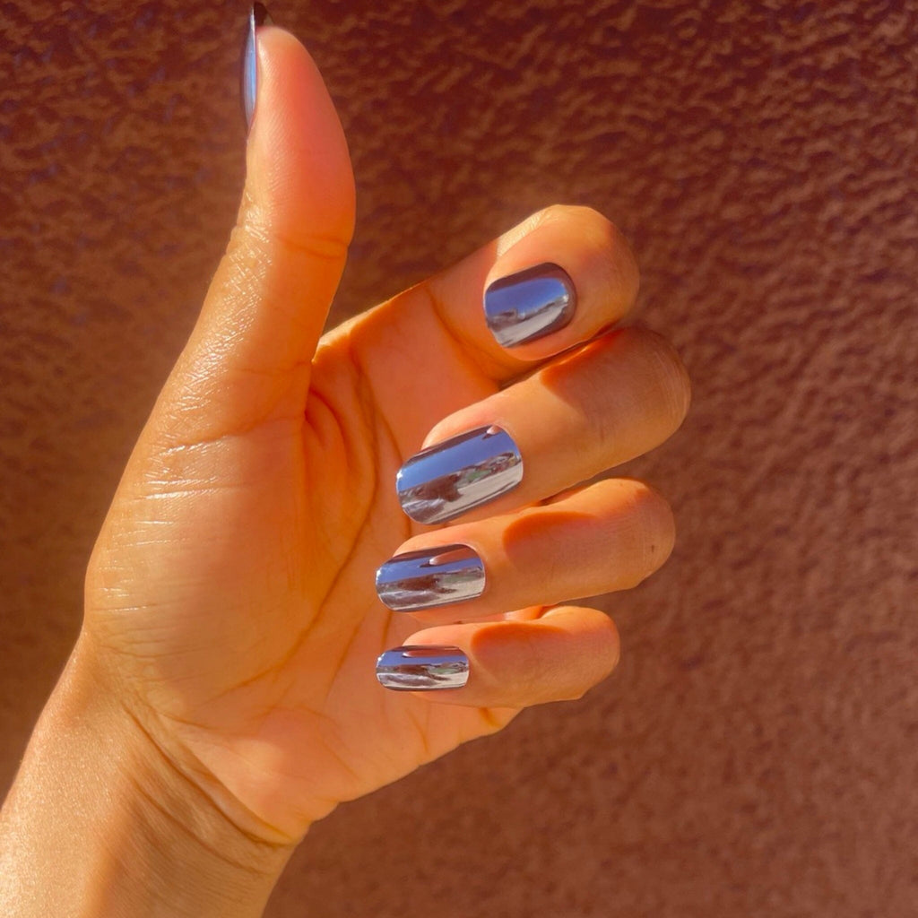 Acrylic-like press on nails in Big Glam Nation's Mini Magnetos worn by brown skinned model against clay-colored background.