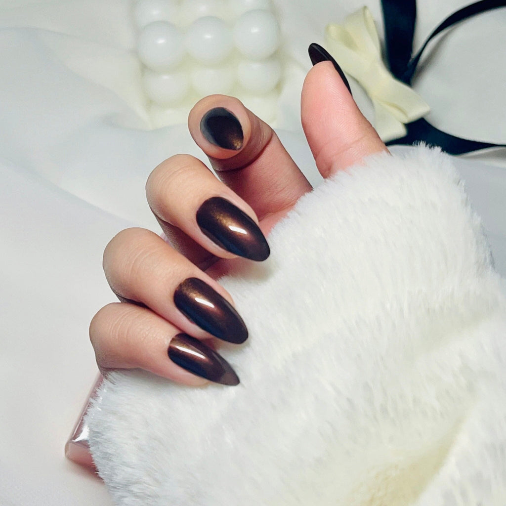 Press on nails in Big Glam Nation's Deep Chocolate worn by fair skinned model in mostly white lifestyle background and surroundings.