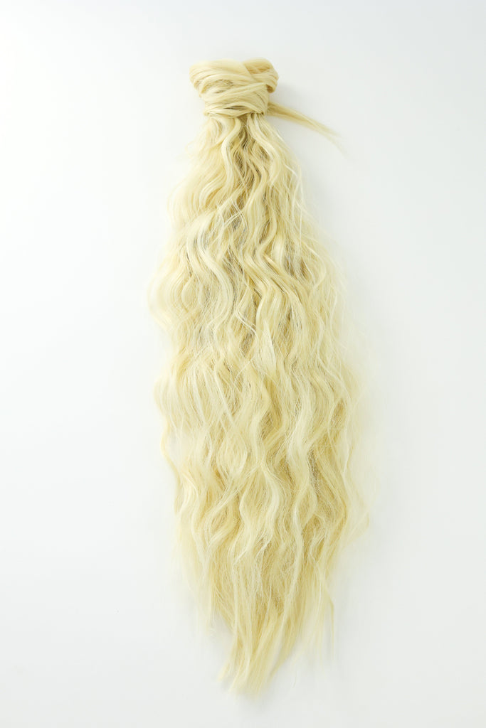 The Big Glam Nation crimped ponytail is laid flat on a white background. The ponytail has a wavy texture, in a bleach blonde color, with a velcro wraparound application.