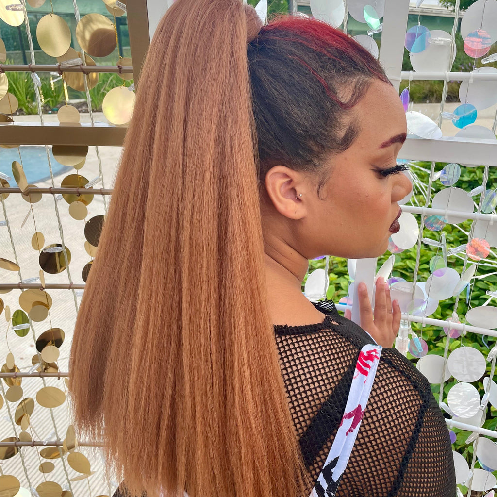 A model wears the Big Glam Nation Blowout Ponytail Extensions in Tannin. (Red Hair Extensions/Orange Red Hair Extensions/Copper Hair Extensions).