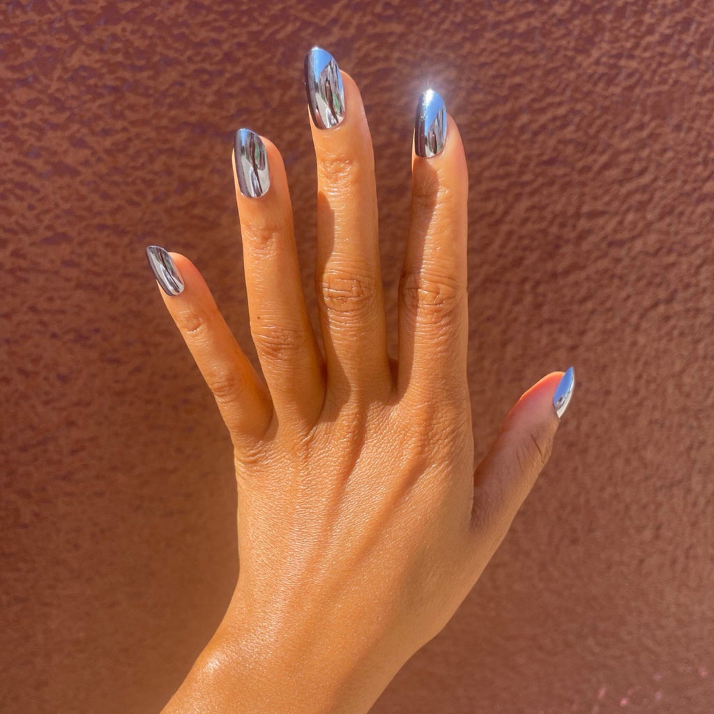 Acrylic like press on nails in  Big Glam Nation's Mini Magnetos worn by brown skinned model against clay-colored wall.