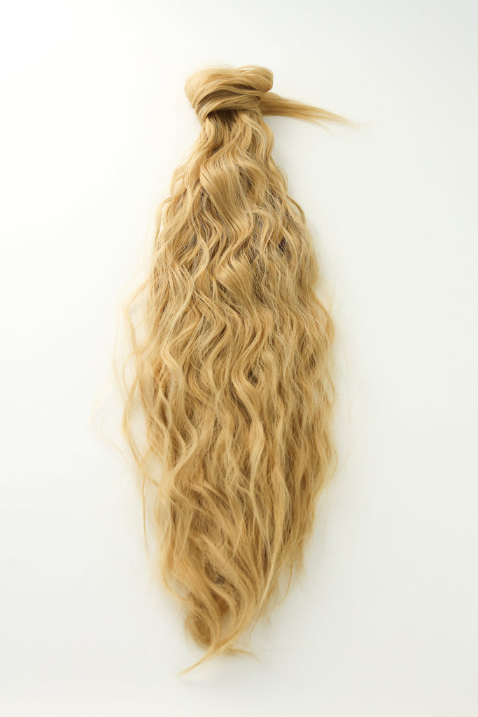 Wavy Ponytail Extensions in BGN's Sandy Blonde laid flat against white background.