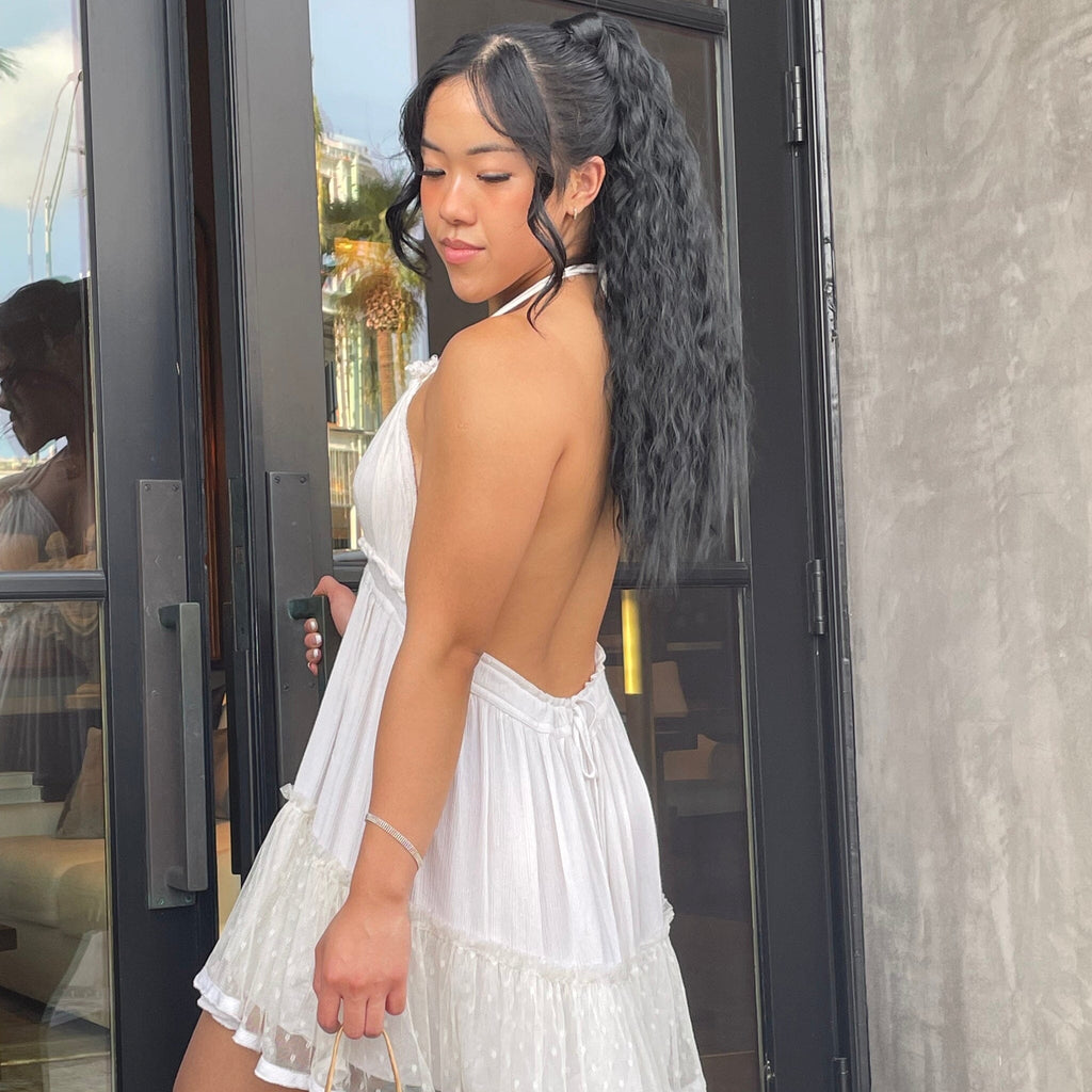 Model wearing Big Glam Nation's Crimped black hair extensions/black ponytail extensions while entering door of luxury retail store.