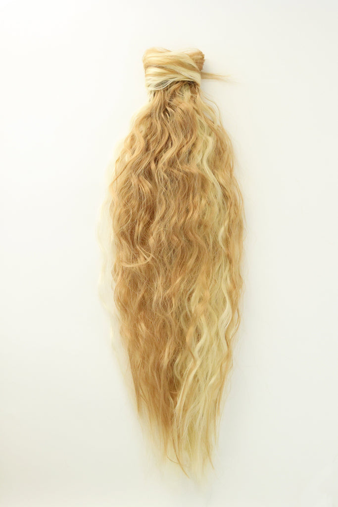 Big Glam Nation Ponytail Extensions are laid against a white background with wavy texture.