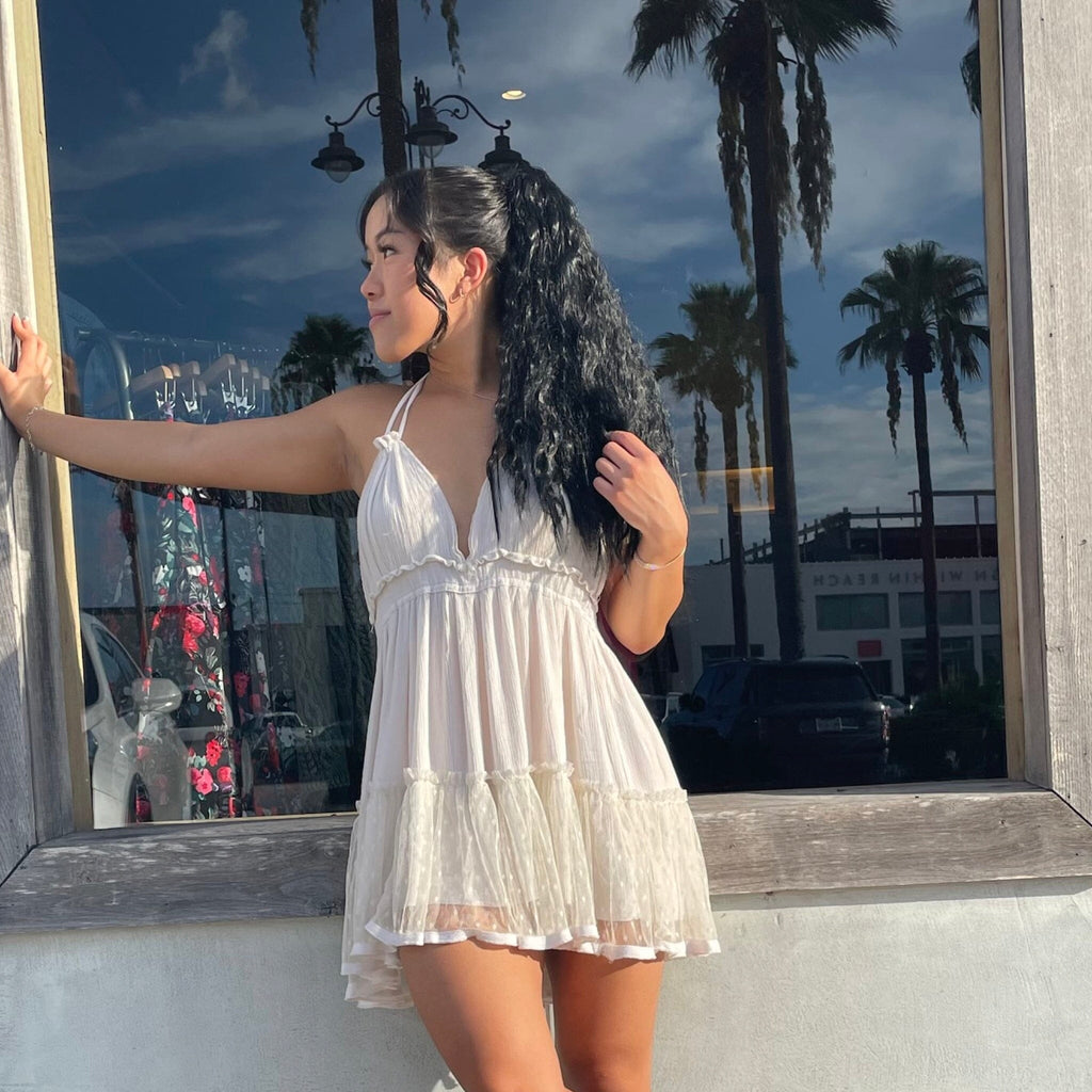 Model wearing Big Glam Nation black hair extensions/black ponytail extensions while standing against retail shop window.