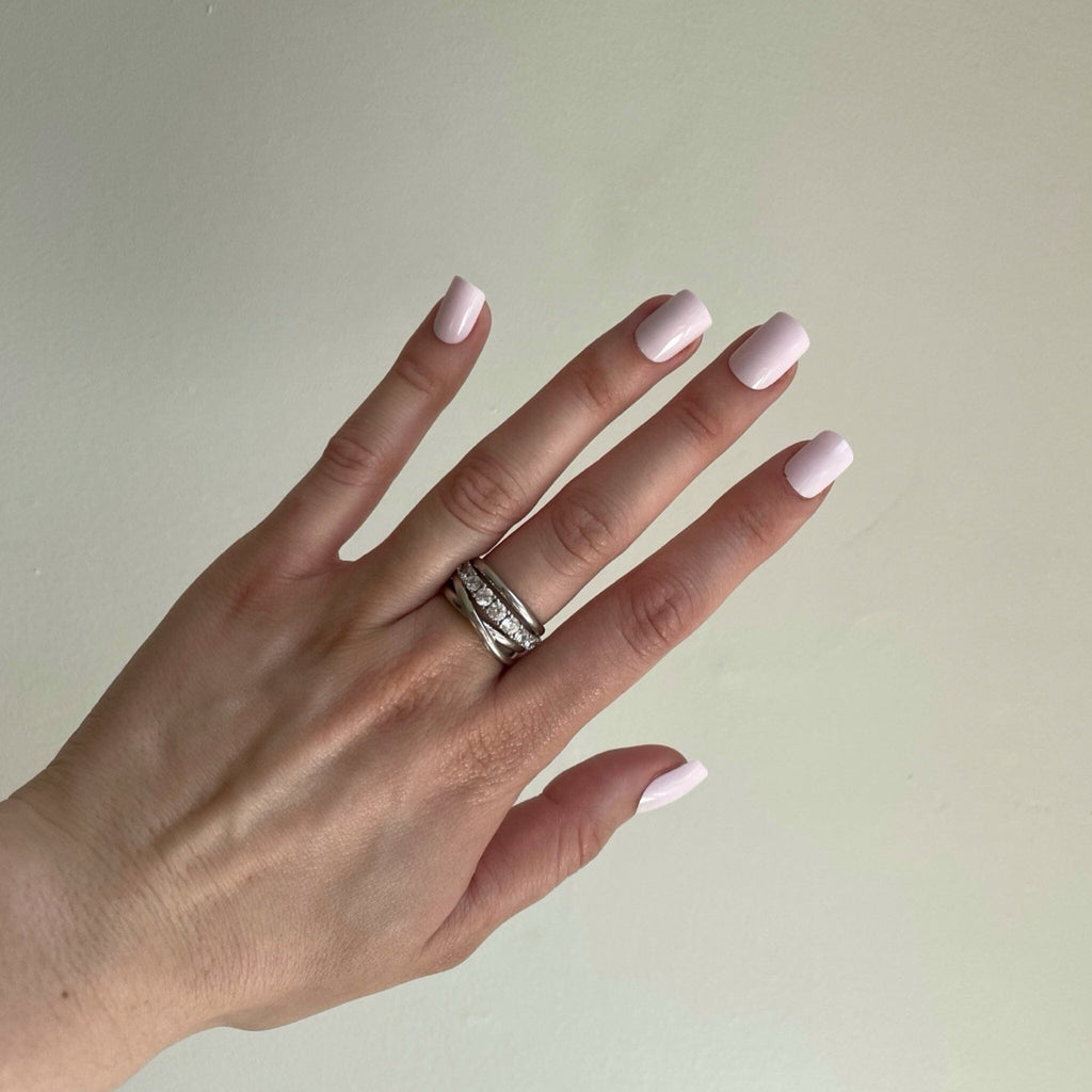 Short Press On Nails in BGN's Soft Pinks worn against neutral background by fair-skinned model.