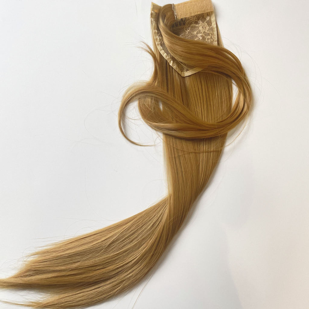 The Big Glam Nation Sleek Ponytail is laid flat against a white background in the color Sandy Brown. Length and shine of the extensions are highlighted.