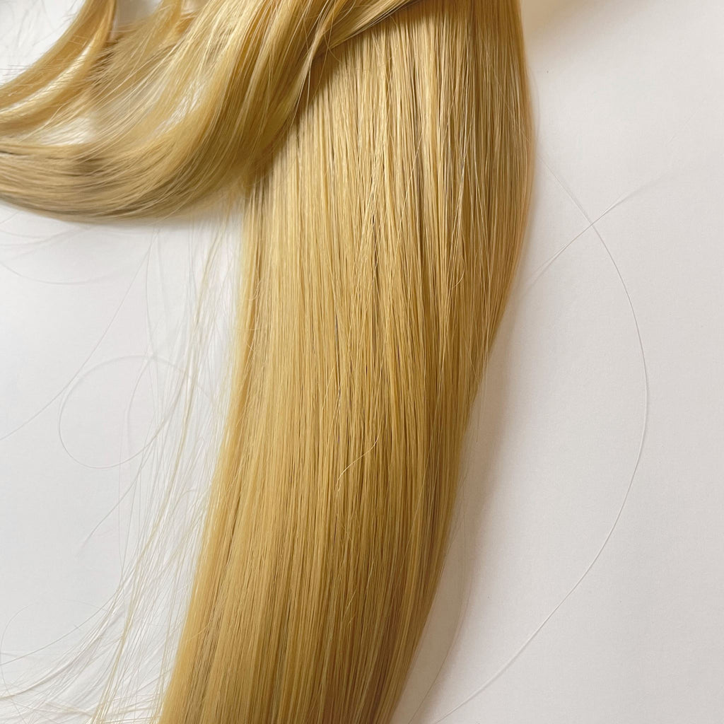 A close up photo is taken of the Big Glam Nation Sleek Ponytail at mid-length. The thickness and vibrant color of the strands are highlighted. 