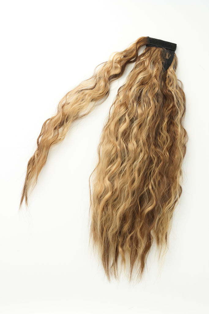 The Big Glam Nation crimped ponytail is laid flat on an off-white background. The ponytail has a wavy texture, in a blended color of varied shades of brown, with a velcro wraparound application.